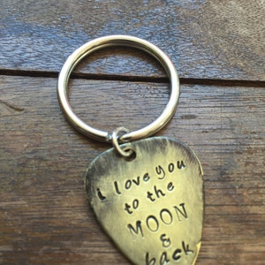 May include: Silver key chain with a guitar pick charm that says "I love you to the moon & back".
