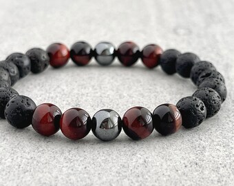 Peut inclure: Un bracelet composé de perles de lave noire, d'œil de tigre rouge et d'hématite.