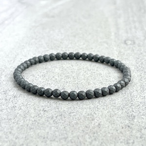 May include: A gray beaded bracelet made of faceted hematite stones.