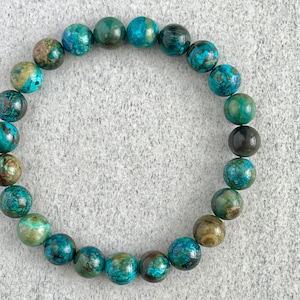 Puede incluir: Un brazalete de piedras preciosas turquesa y verde con cuentas redondas. El brazalete est&aacute; hecho de piedras naturales y tiene un aspecto &uacute;nico y terroso.