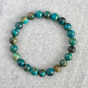 Puede incluir: Un brazalete de piedras preciosas turquesa y verde con cuentas redondas.