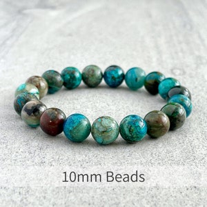 Puede incluir: Un brazalete hecho con cuentas de turquesa y jaspe marr&oacute;n de 10 mm. Las cuentas son redondas y tienen un acabado natural y pulido.