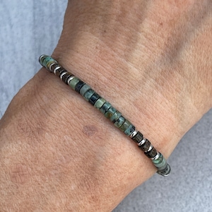 Peut inclure: Un bracelet en perles vertes et brunes avec des accents argentés.