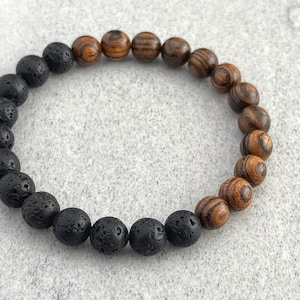 Peut inclure: Un bracelet en perles de lave noire et de bois. Le bracelet est composé de perles alternées de lave noire et de bois brun.