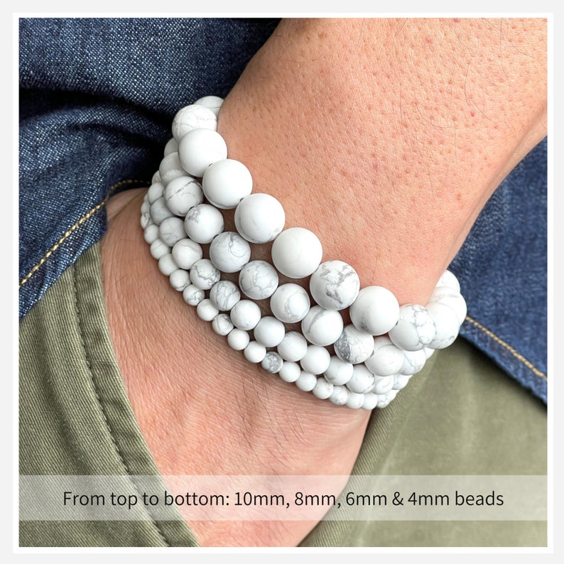 Puede incluir: Cuatro pulseras de cuentas de howlite blancas apiladas en la mu&ntilde;eca de una persona. De arriba a abajo, las cuentas miden 10 mm, 8 mm, 6 mm y 4 mm.