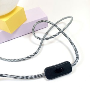 May include: A black and white striped cord with an inline on/off switch. The cord is coiled and the switch is in the off position.