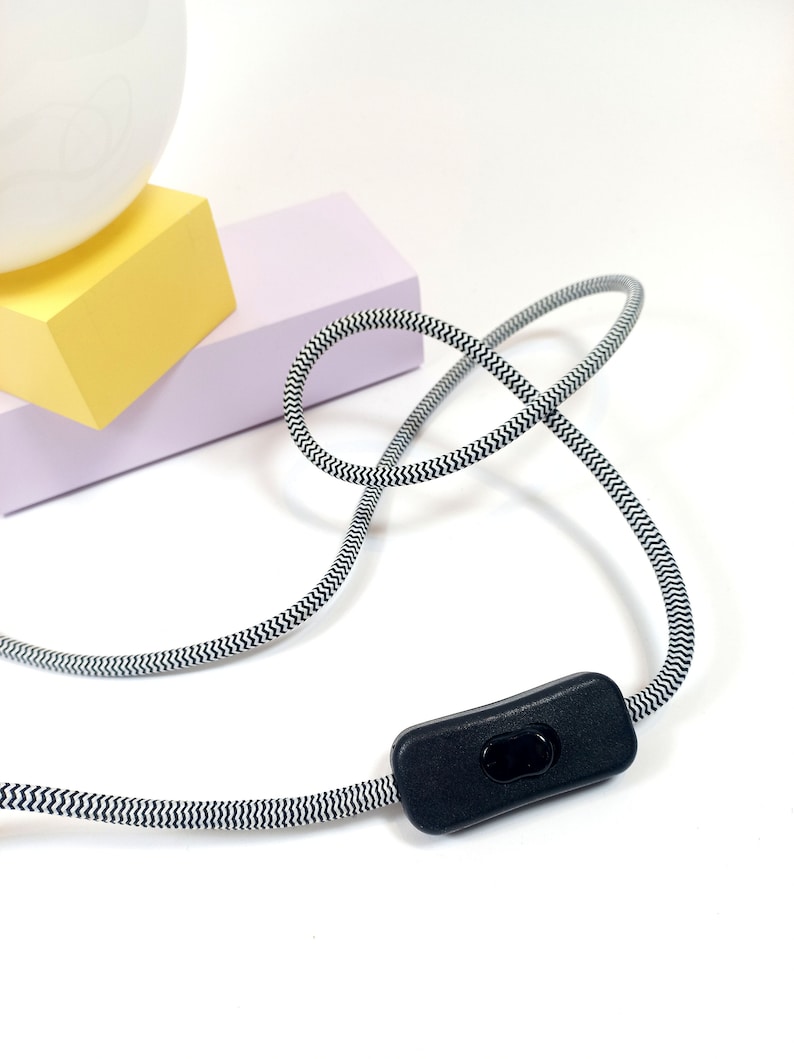 May include: A black and white striped cord with an inline on/off switch. The cord is coiled and the switch is in the off position.