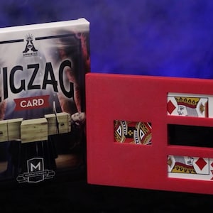 May include: A red card trick prop with three slots, each revealing a different playing card. The top slot shows the King of Diamonds, the middle slot is empty, and the bottom slot shows the Queen of Diamonds. The prop is labeled "Zigzag Card" on the box.