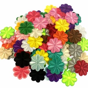 May include: A large pile of colorful felt flower embellishments. The flowers are all the same size and shape, but they come in a variety of colors, including red, pink, yellow, green, blue, and purple.