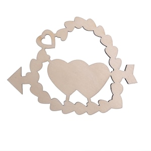 Puede incluir: Corte de madera de dos corazones con una flecha que los atraviesa, rodeado de una corona de corazones más pequeños. Los corazones están en blanco y listos para ser pintados o decorados.