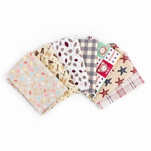 May include: A set of six fabric squares with different patterns. The patterns include leaves, alphabet letters, a plaid pattern, a bear with stars, a starfish, and a plaid pattern with red and white stripes.