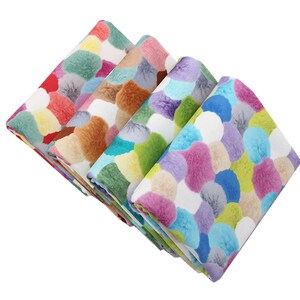 May include: Four fabric swatches with a colorful pom-pom pattern. The swatches are folded and stacked on top of each other. The colors include red, orange, yellow, green, blue, purple, and brown.
