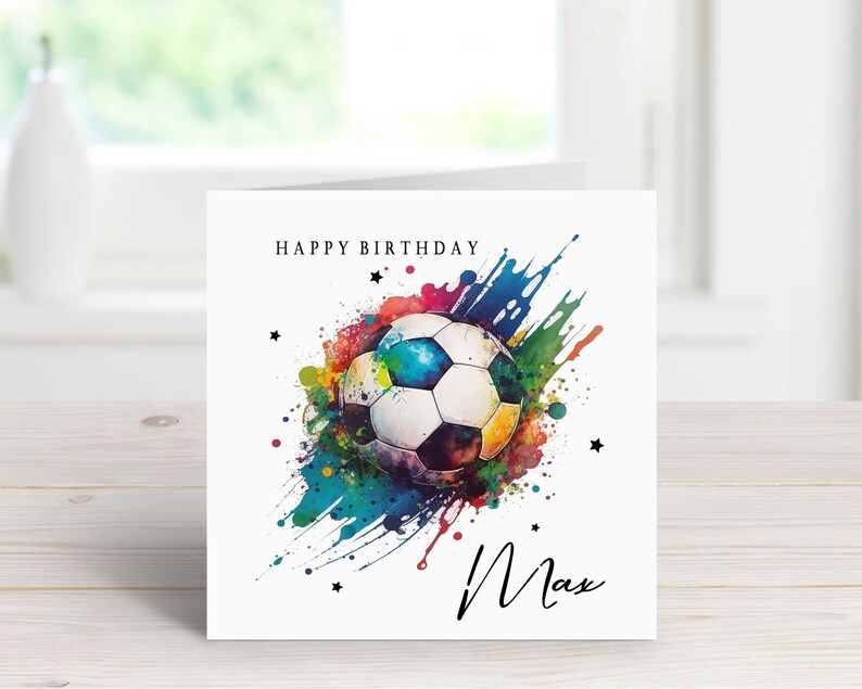 May include: A birthday card with a colorful watercolor design of a soccer ball and the words "Happy Birthday" and "Max".