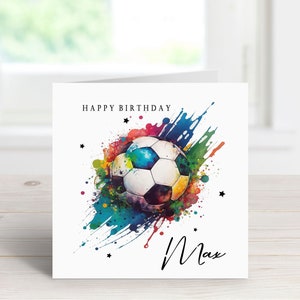 May include: A white card with a colorful watercolor design of a soccer ball and the words "Happy Birthday Max".