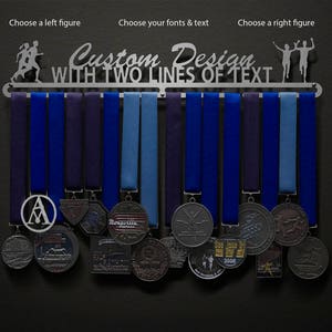 May include: A silver medal rack with the text "Custom Design, WITH TWO LINES OF TEXT" and two running figures. The rack has 12 medal hangers and is displaying a variety of medals with different designs and colors.