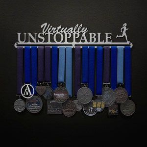 May include: A silver medal display rack with the words "Virtually Unstoppable" and a running figure. The rack has 12 hooks and is holding a variety of medals with blue and silver ribbons.