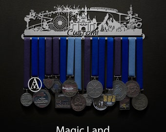 May include: A metal medal display rack with a custom design featuring a whimsical amusement park scene. The rack has 12 hooks for hanging medals and is labeled "Custom!" The rack is decorated with blue and silver ribbons and has a variety of medals hanging from it.