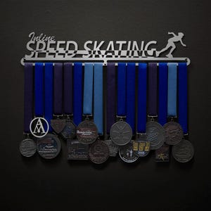 May include: A metal medal display rack with the words "Inline Speed Skating" and a silhouette of a skater. The rack has 12 hooks and is holding a variety of medals with blue and black ribbons.