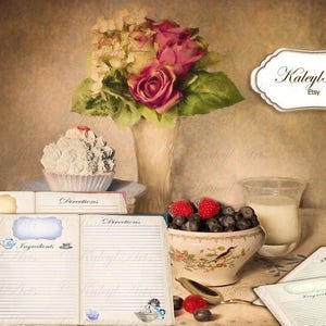May include: Two vintage recipe books with blank pages for writing down recipes. The books are open and have a floral design on the cover. The books are on a table with a cupcake, a vase of flowers, and a bowl of berries.