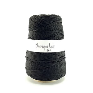 May include: A spool of black cord with a white label that reads "Younique Lab ER8"