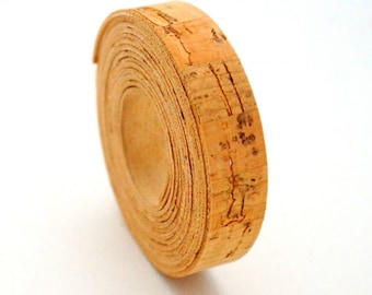 May include: A roll of natural cork ribbon, a thin strip of cork material, rolled up into a coil. The cork is a light brown color and has a natural, slightly rough texture.