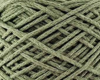 May include: A close-up of a spool of green cotton yarn. The yarn is tightly wound and has a rough texture.