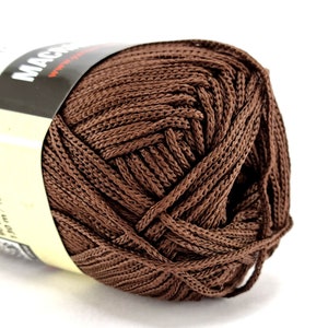 May include: A ball of brown yarn, with a label that says "MACRAME" on it.