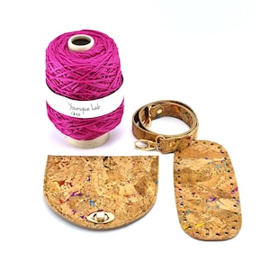 May include: A set of cork fabric pieces for crafting a bag, including a strap, a flap, and a base. The fabric has a speckled pattern with colorful flecks. A spool of pink yarn is also included.