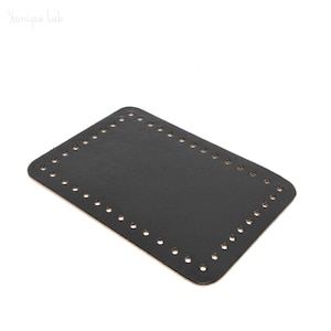 Peut inclure: Base en cuir noir avec des trous pour le tissage, utilisée pour la fabrication de sacs ou de pochettes.