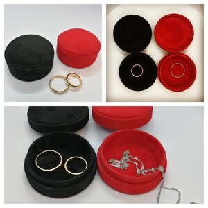 May include: A collage of jewelry boxes in black and red. The boxes are round and made of a soft material. Gold rings and a silver chain are displayed inside the boxes. The boxes are open and closed, showcasing the jewelry.