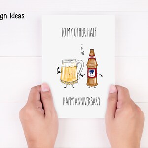 May include: A white card with a hand-drawn illustration of a beer mug and a beer bottle holding hands. The text on the card reads "To my other half Happy Anniversary".