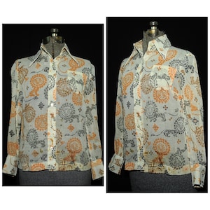 May include: A white sheer button-up shirt with a long sleeve and a collar. The shirt has a floral pattern in shades of orange and gray.