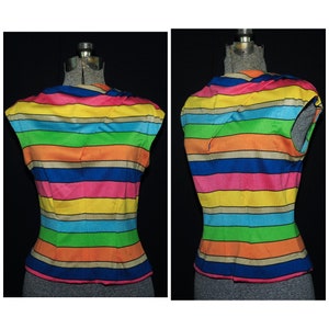 Puede incluir: Una blusa sin mangas con un patrón de rayas de arcoíris. Las rayas son en tonos de amarillo, naranja, rojo, rosa, azul, verde y marrón.