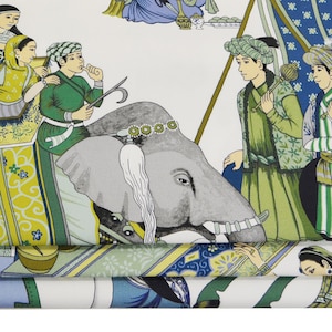 May include: A white fabric with a repeating pattern of people riding an elephant, a palanquin, and other figures. The figures are dressed in colorful clothing and the background is white.