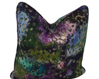 May include: A decorative throw pillow with a colorful abstract pattern featuring shades of purple, blue, green, and gold. The pattern resembles a leopard print with a watercolor effect.