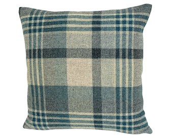 May include: A square throw pillow with a blue, gray, and beige plaid pattern.