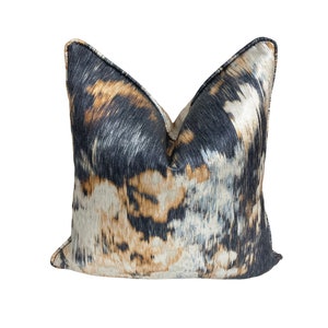 May include: A decorative throw pillow with a black, brown, and white abstract pattern.