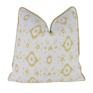 May include: A white throw pillow with a yellow geometric pattern and a yellow border.