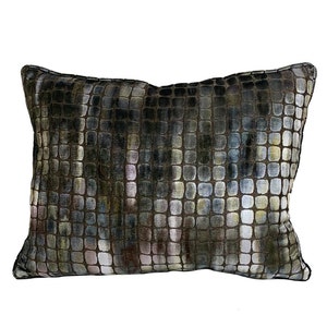 May include: A rectangular pillow with a geometric pattern in shades of brown, gray, and white. The pillow has a subtle sheen and a soft, plush texture.