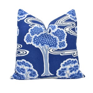 a blue and white pillow with a tree on it