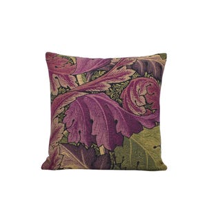 a purple and green floral pillow on a white background