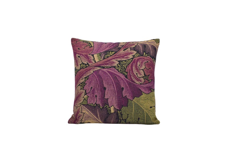 a purple and green floral pillow on a white background