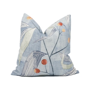 May include: A blue cushion with a geometric pattern of white lines and orange circles. The cushion is made of a soft, textured fabric.