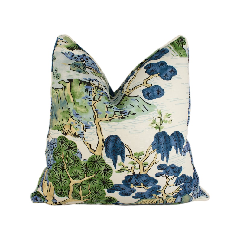 May include: A white pillow with a blue and green floral pattern. The pattern features stylized trees and flowers.