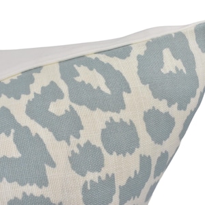 a close up of a blue and white animal print pillow