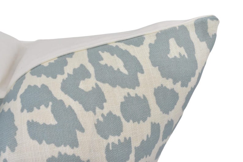 a close up of a blue and white animal print pillow