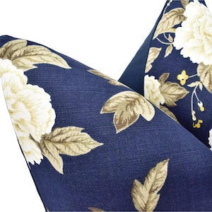 a close-up view of a blue fabric with a floral pattern, featuring white flowers and leaves.