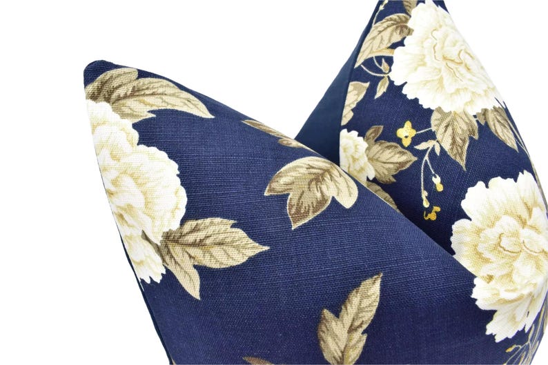 a close-up view of a blue fabric with a floral pattern, featuring white flowers and leaves.
