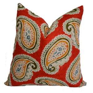 May include: Red pillow with a paisley pattern in shades of green, blue, yellow, and white.