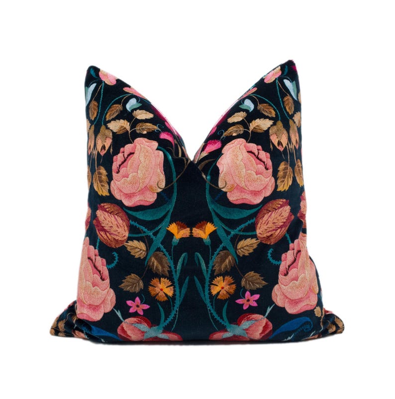 a blue pillow with pink flowers on it